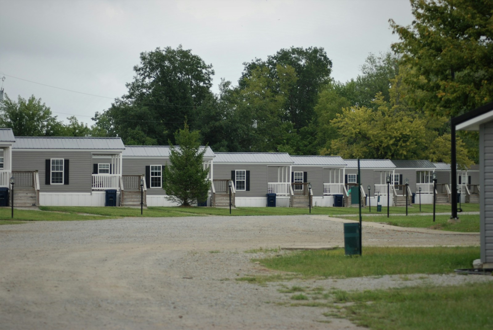 white concrete building near green trees during daytime, mobile home